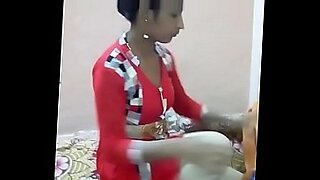 a young girl bends over and inserts a glass dildo